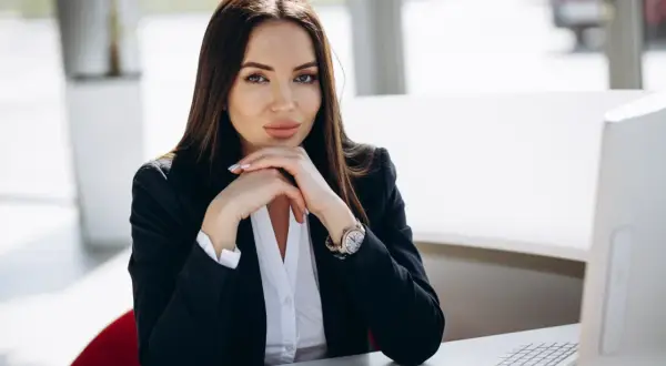 Elegancka kobieta w czarnej marynarce i białej koszuli, idealny strój, by wiedzieć, co ubrać na rozmowę kwalifikacyjną.