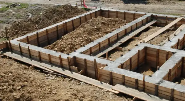 Betonowy fundament w drewnianym szalunku, gotowy do dalszych prac budowlanych.