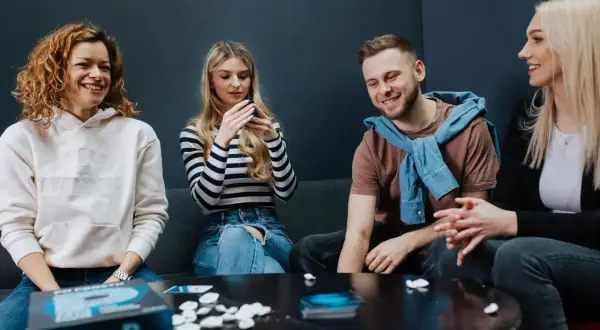 Grupa przyjaciół śmieje się, grając w grę słowną "Po Prostu P".