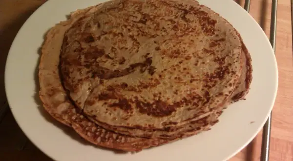 En hög med tunna pannkakor på en vit tallrik. Perfekt protein frukost för att gå ner i vikt.