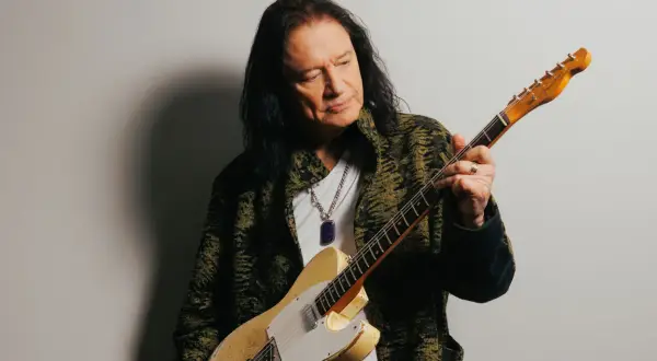 Musician Todd Rundgren, with his signature long dark hair, holds a vintage Fender Telecaster. His career has undoubtedly contributed to his impressive reb beach net worth.