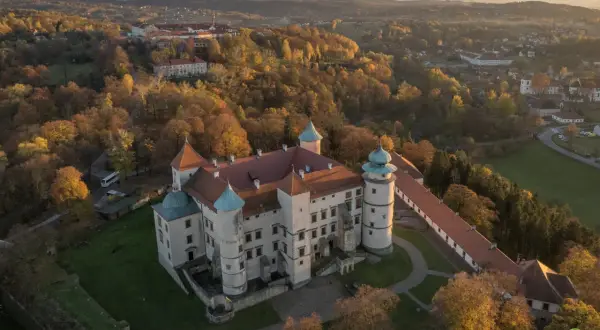 Zamek w jesiennej scenerii, otoczony złotymi liśćmi. Idealne miejsce na jesienny thanksgiving.