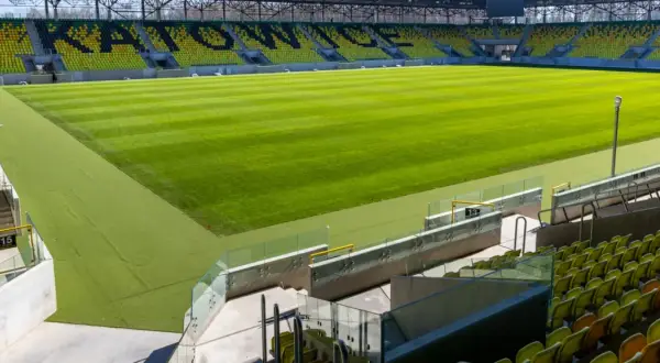 Nowy stadion GKS Katowice, z zieloną murawą i żółto-czarnymi trybunami, czeka na kibiców. Lokalizacja obiektu to ul. Bukowa 1.