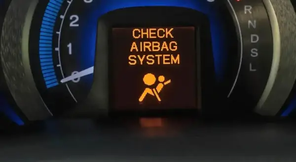 Na desce rozdzielczej świeci się pomarańczowa kontrolka poduszki powietrznej z napisem "CHECK AIRBAG SYSTEM".
