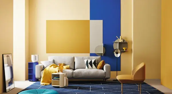 Modernes wohnzimmer blau gelb: graues Sofa, gelbe Decke, blaue Akzente und geometrische Muster auf dem Teppich.
