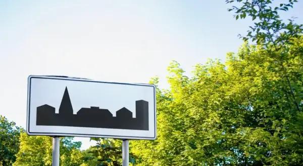 Znak teren zabudowany z sylwetką miasta. Wjeżdżamy do miasta, gdzie czekają nas miejskie krajobrazy.