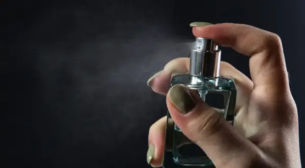 Dłoń rozpyla perfumy. Chcesz wiedzieć, jak sprawdzić, czy perfumy są oryginalne? Zwróć uwagę na detale flakonu i zapach.