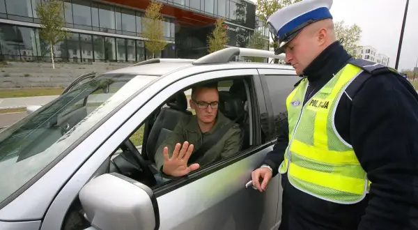Policjant rozmawia z kierowcą, który może otrzymać zatrzymanie prawa jazdy na 3 miesiące.