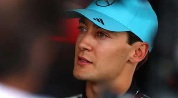 George Russell, piloto de F1, con gorra azul y mirada concentrada.