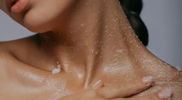 Delikatny peeling z **sodium lactate** na szyi i dekolcie. Skóra nawilżona i gładka.