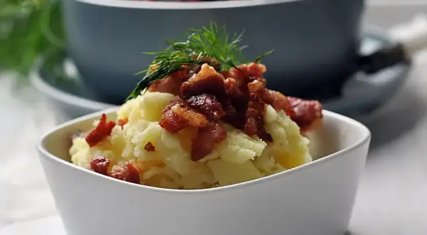 Pyszna zupa z botwiny z ziemniakami, podana z chrupiącym boczkiem i koperkiem.