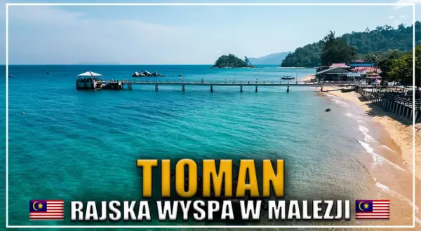 Malajska wyspa Tioman, z turkusową wodą, piaszczystą plażą i pomostem prowadzącym do lądu.