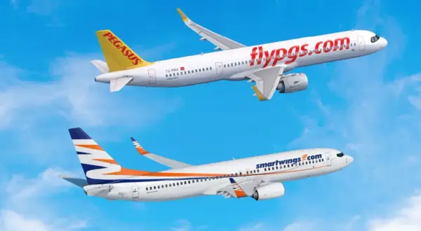 Dwa samoloty, jeden z napisem "flypgs.com" i drugi z logo Smartwings, lecą na tle błękitnego nieba. Smartwings flota w locie.