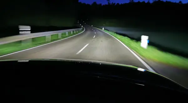 Nocna jazda po krętej drodze oświetlonej przez inteligentne światła matrycowe.