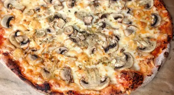 Pyszna pizza z pieczarkami, idealnie wypieczona w 180 stopniach.