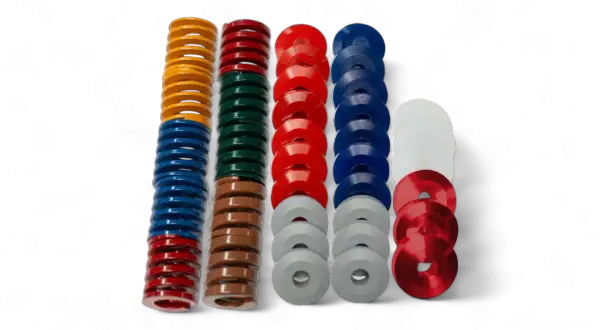 Molte molle colorate e rondelle in elastomero, un materiale flessibile e resistente, sono disposte in colonne su sfondo nero.