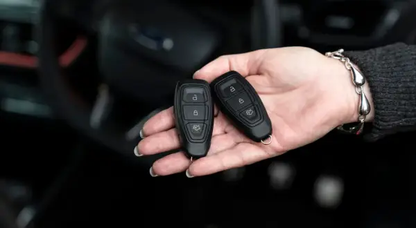 Dwie karty do kluczyka samochodowego w dłoni. Zastanawiasz się, keyless entry co to? To wygoda bez kluczyka.
