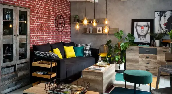 Męski pokój inspiracje: loftowy styl z ceglaną ścianą, czarną kanapą, drewnianymi meblami i industrialnymi lampami.