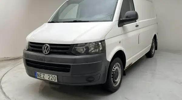 Vit VW Transporter T5 med rostskador undertill. Registreringsskylt NEZ 220.