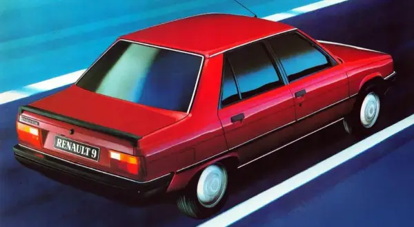 Czerwony Renault 9 pędzi po drodze, odbijając się w niebieskim tle.