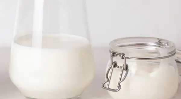 Un verre de lait et un pot de lait de beurre, prêts pour une recette gourmande.