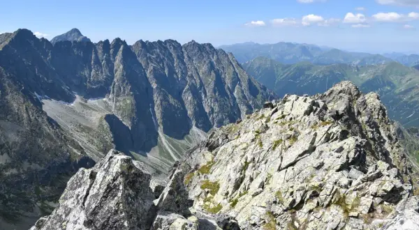 Kamienista grań na trasie na Koprowy Wierch. Majestatyczne szczyty Tatr Wysokich w tle.