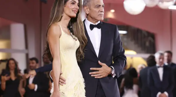 Elegancka para na czerwonym dywanie. Ona w żółtej sukni, on w garniturze. Idealny przykład damskiego black tie dress code.