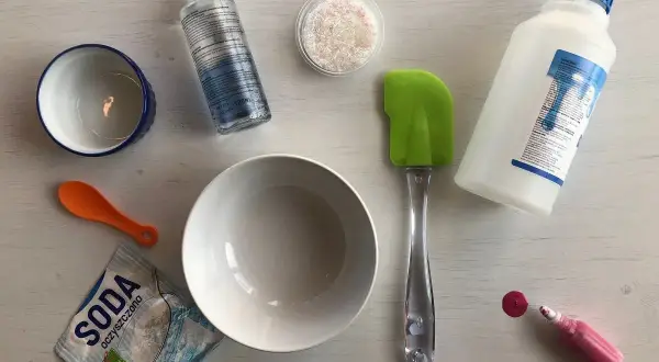 Wszystko do robienia slimów: klej, soda, aktywator, miseczki, łyżeczka i brokat.