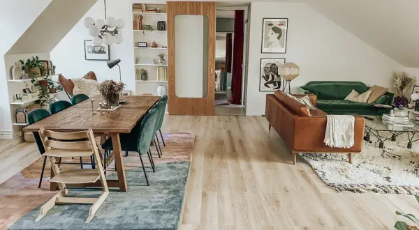 Två mattor i samma rum: en stor, abstrakt matta under matbordet och en mindre, mönstrad matta framför soffan.