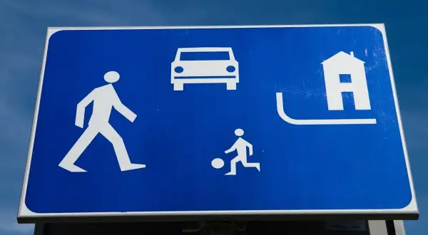 Znak informuje o strefie zamieszkania zasady: piesi, dzieci bawiące się piłką i samochody mają tu równe prawa.