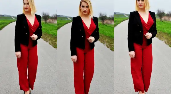 Kobieta w czerwonym kombinezonie i czarnej marynarce prezentuje stylowe czerwony kombinezon stylizacje na tle drogi i zieleni.