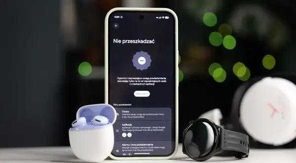 Smartfon z włączonym trybem nie przeszkadzać Samsung, obok słuchawki i smartwatch.