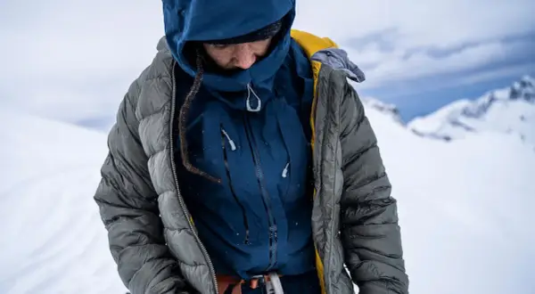 Person in Daunenjacke, bereit für die Kälte. Die Daunenjacke waschen ist wichtig für die Langlebigkeit.