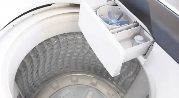 Cassetto detersivo lavatrice aperto, mostra come usare il detersivo liquido. La vaschetta è pronta per il bucato.