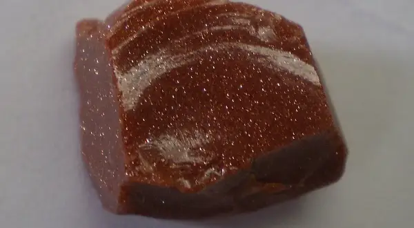 Ein glitzernder goldfluss edelstein mit schimmernden Einschlüssen, der wie ein Sternenhimmel aussieht.