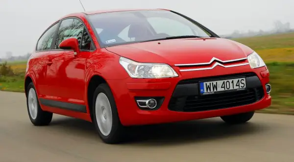Czerwony Citroen C4 2008 na drodze, z widocznym numerem rejestracyjnym WW 4014S.