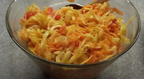 En skål med kålsallad, morötter och tomatbitar. Perfekt som tillbehör till middagen, en riktig 3 veckors sallad!