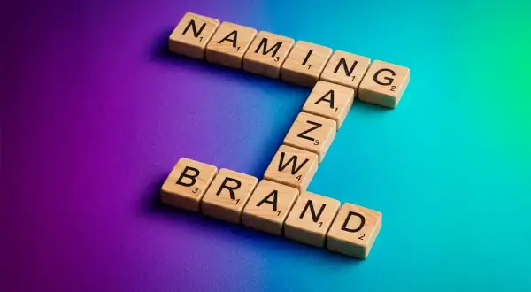 Drewniane klocki z literami tworzą słowa "NAMING" i "BRAND". To klucz do sukcesu każdej firmy.