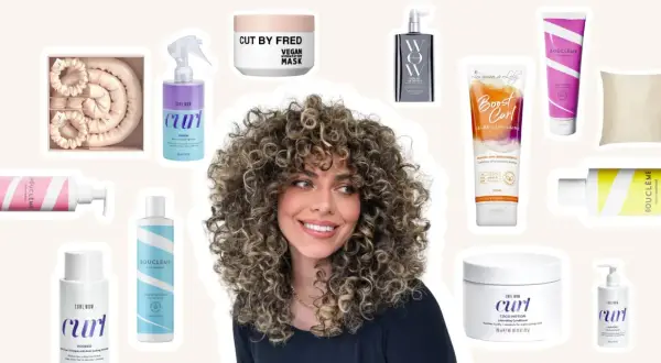 Une femme aux cheveux bouclés naturels rayonne, entourée de produits pour le soin des cheveux bouclés.