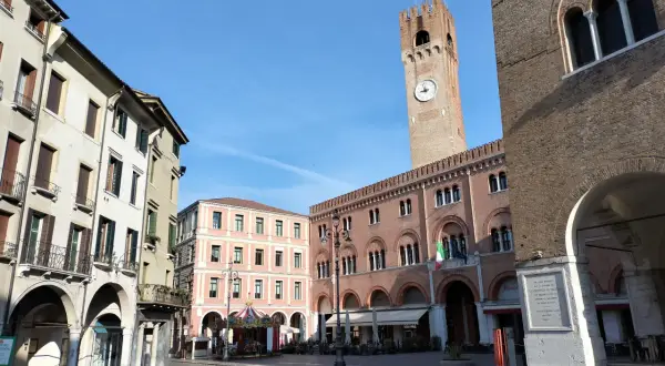 Rynek w Treviso, niedaleko Wenecji, z wieżą zegarową i karuzelą.