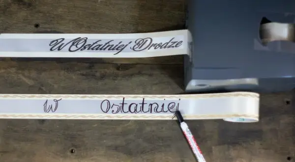 Szarfa pogrzebowa z napisem "W Ostatniej Drodze" jest drukowana i pisana ręcznie.