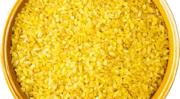 Złocista kasza bulgur w ceramicznej misce, gotowa do przygotowania pysznego posiłku.