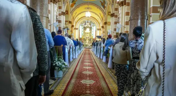 15 września. Ludzie w kościele, wzdłuż czerwonego dywanu, czekają na uroczystość.