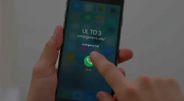 Dłoń naciska przycisk "Emergency Call" na ekranie telefonu. To może być pomocne, jak odblokować telefon zablokowany przez operatora Plus.