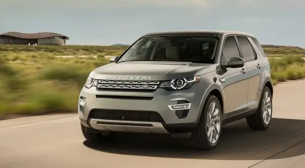 Szary Land Rover Discovery Sport w ruchu. Wiele osób szuka land rover discovery sport opinie przed zakupem.