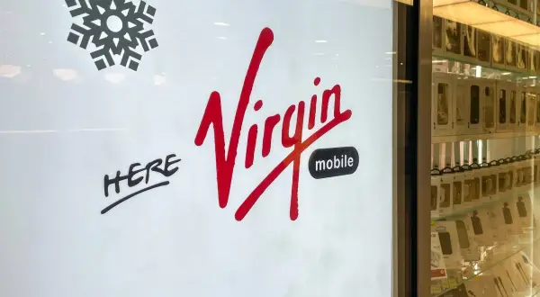 Logo Virgin Mobile, z napisem "HERE". Właściciel sieci Virgin Mobile zaprasza do swojego sklepu.