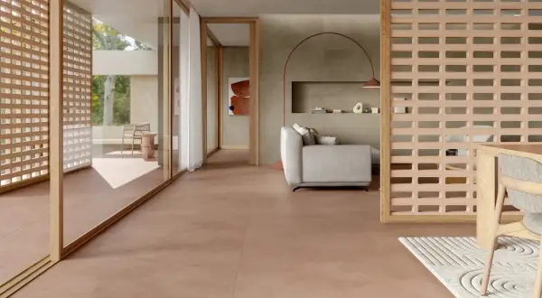 Pavimento in gres porcellanato rosso per esterni, che crea un'atmosfera calda e accogliente in un soggiorno moderno con arredi minimalisti.