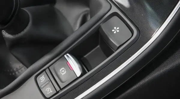 Bouton de frein à main électronique et autres commandes dans une voiture. Le frein à main ne serre plus, prix de la réparation à considérer.