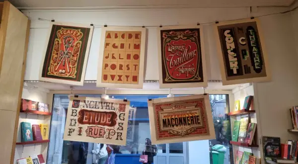 Affiches vintage avec un alphabet décoratif, des publicités de café, de laines et de théâtre.