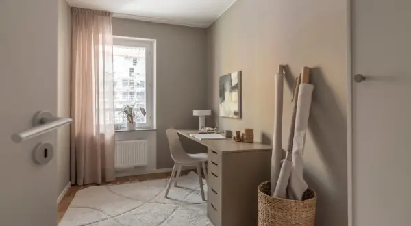 En ljus och inspirerande arbetsplats kontor med skrivbord, stol, textilier och konst.